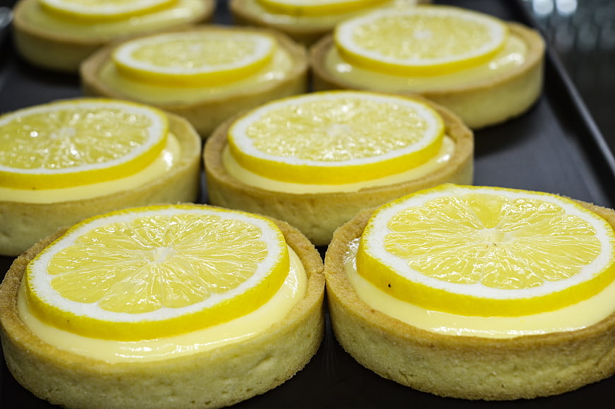 Fresh Lemon Tarts with Glazed Slices on Dark Tray