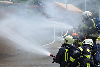 Firefighters spraying water hose during training exercise
