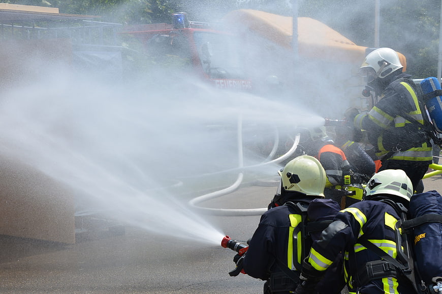 Firefighters spraying water hose during training exercise