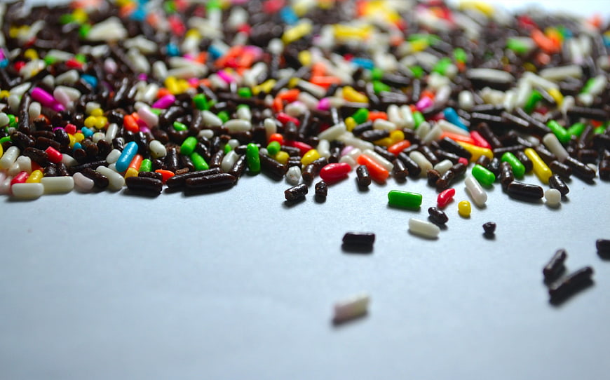 Colorful Chocolate Sprinkles Scattered On White Surface