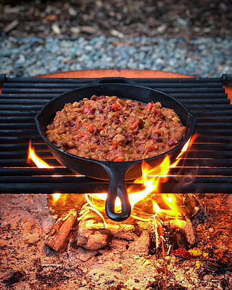Cast Iron Skillet of Chili Cooking Over Campfire