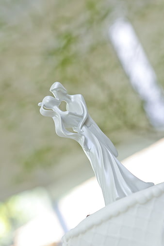 White ceramic wedding cake topper of a dancing couple