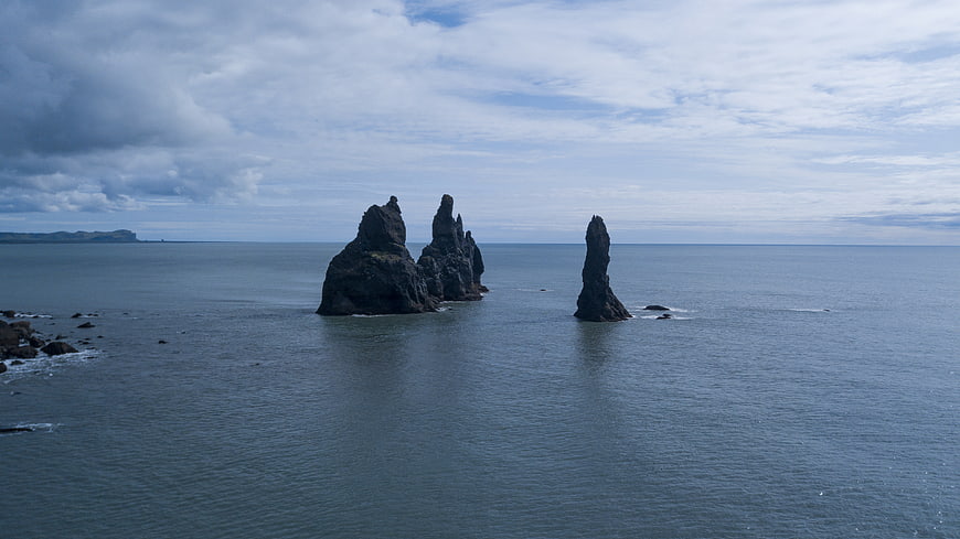 Dramatic Sea Stacks on Icelandic Coastline Under Cloudy Sky