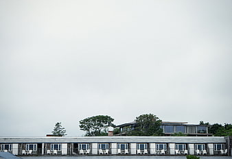 Motel exterior with white chairs and overcast sky
