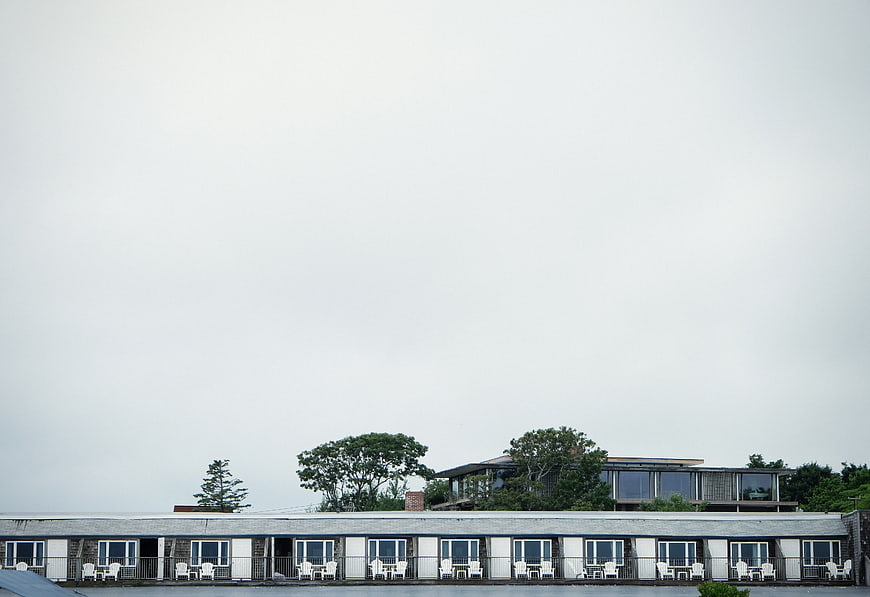 Motel exterior with white chairs and overcast sky