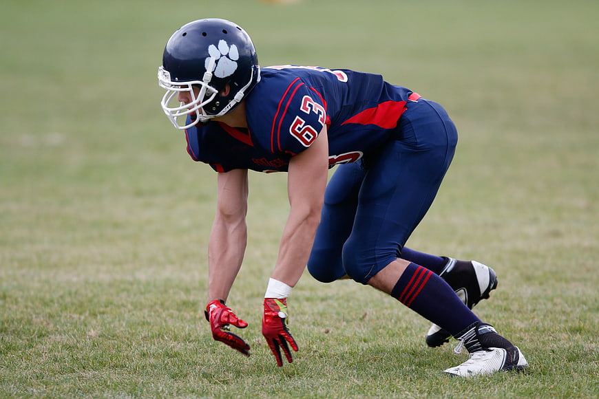 American Football Player in Blue Uniform Ready Stance