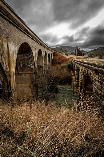 Dramatic historic stone railway viaducts under stormy sky