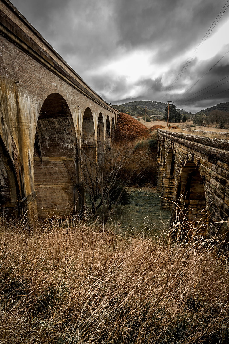 Dramatic historic stone railway viaducts under stormy sky