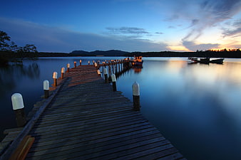 Serene Wooden Pier at Sunset with Calm Water Reflections