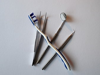 Dental tools and toothbrush on white background