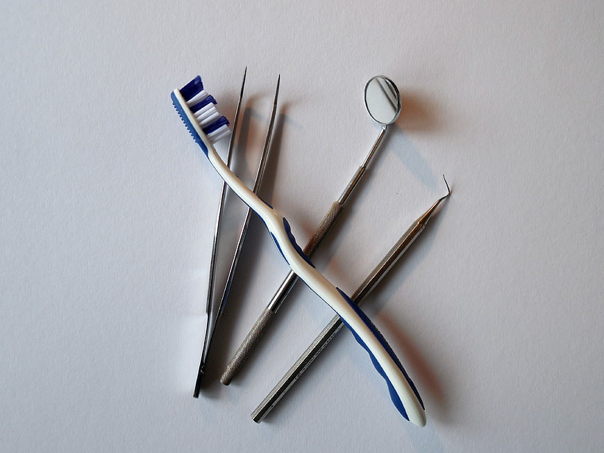 Dental tools and toothbrush on white background