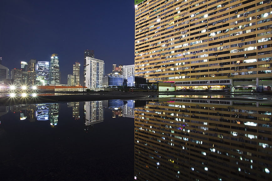 Nighttime urban skyline with building reflections in water