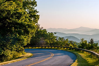 Winding Mountain Road with Blue Ridge Parkway Sign and Misty Peaks