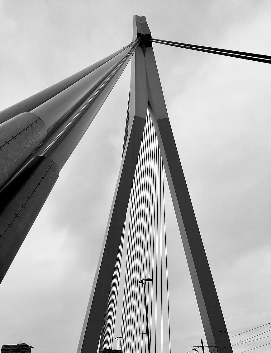 Low angle black and white view of modern cable-stayed bridge tower