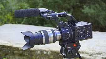 Professional Sony Video Camera with Microphone on Tripod Outdoors