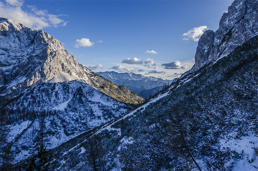 Snowy Mountain Valley with Blue Sky and Clouds