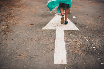Woman walking on road arrow with teal dress