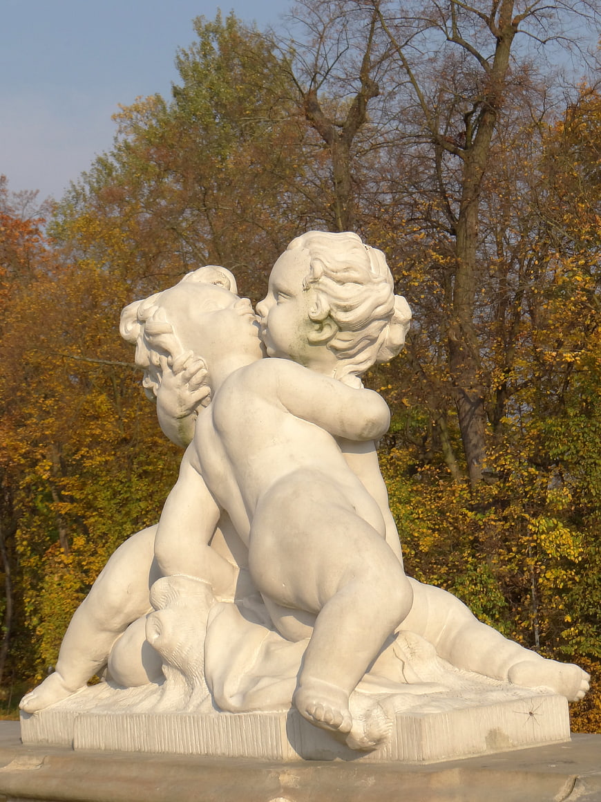 White Marble Putto Sculpture in Autumn Park