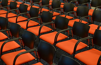 Rows of empty orange and black conference chairs