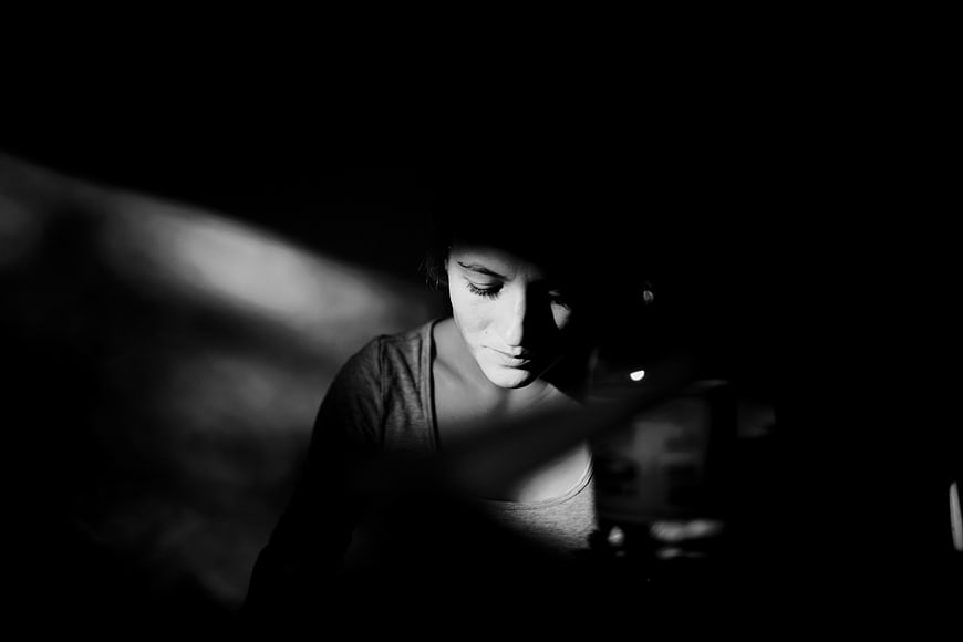 Dramatic black and white portrait of a woman in shadow