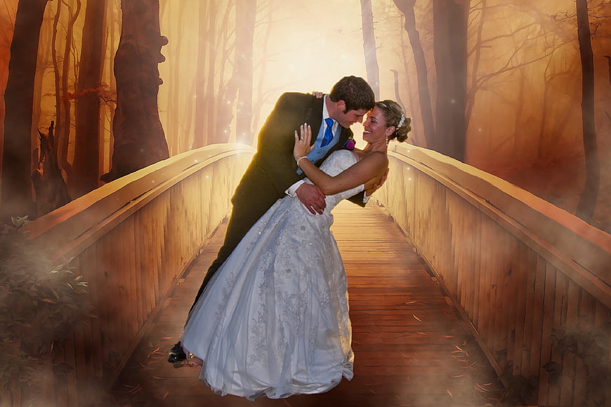 Romantic Wedding Couple Dancing on Misty Wooden Bridge in Autumn Forest