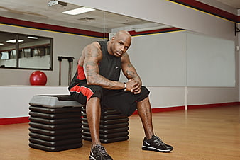 Athletic man resting on gym step platform during workout