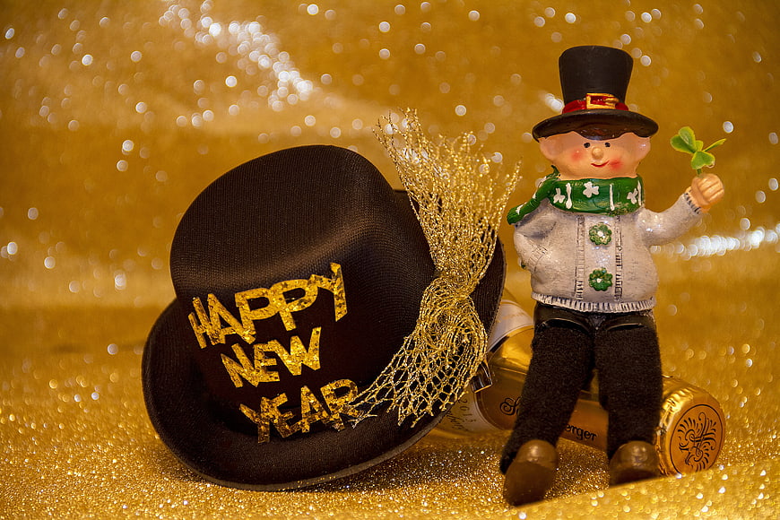 Happy New Year Top Hat and Figurine on Gold Background