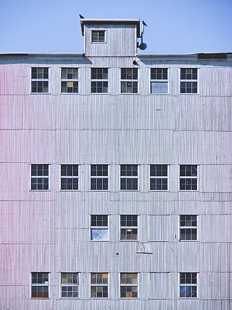 Industrial corrugated metal building facade with grid of windows