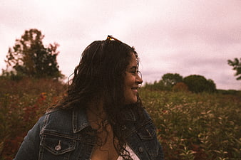 Smiling woman in denim jacket in autumn field
