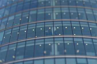 Modern glass office building facade with blurred interior view