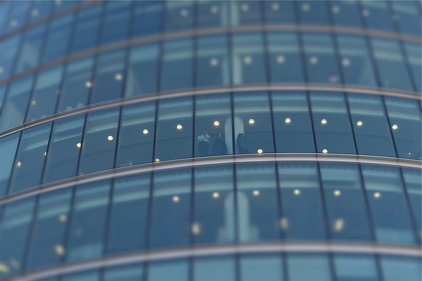 Modern glass office building facade with blurred interior view