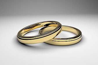 Two interlocking gold wedding rings on a white background