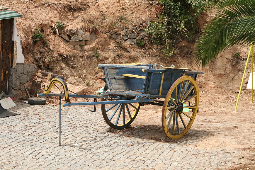 Rustic blue and yellow wooden cart on cobblestone