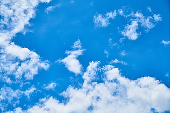 Bright Blue Sky with Fluffy White Clouds Background