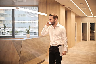 Happy businessman talking on phone in modern office