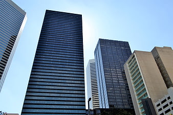 Low angle view of modern glass skyscrapers against blue sky