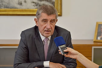 Senior politician in suit being interviewed with handheld microphone