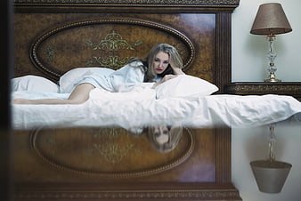 Blonde Woman In White Robe Lying On Bed With Reflection