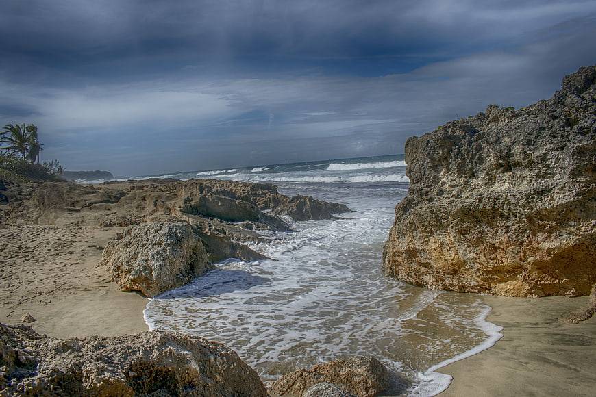 Dramatic Rocky Beach Landscape with Ocean Waves and Cloudy Sky