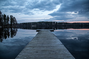 Serene Wooden Dock on Calm Lake at Dusk with Reflections