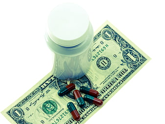 Medicine Bottle And Pills On US Dollar Bill