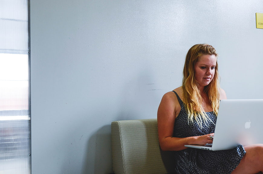 Young woman working on laptop in modern office lounge