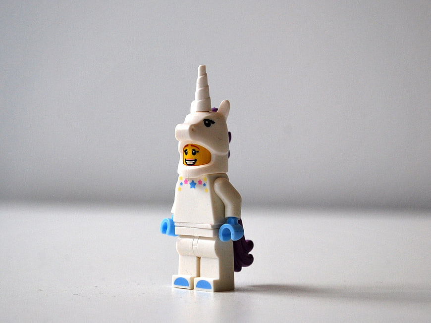 Lego Minifigure in White Unicorn Costume on Gray Background