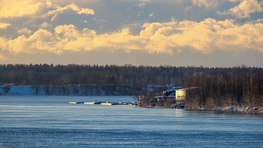 Panoramic Winter River Landscape with Golden Clouds and Snowy Banks