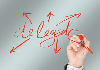 Hand writing delegate with arrows on whiteboard