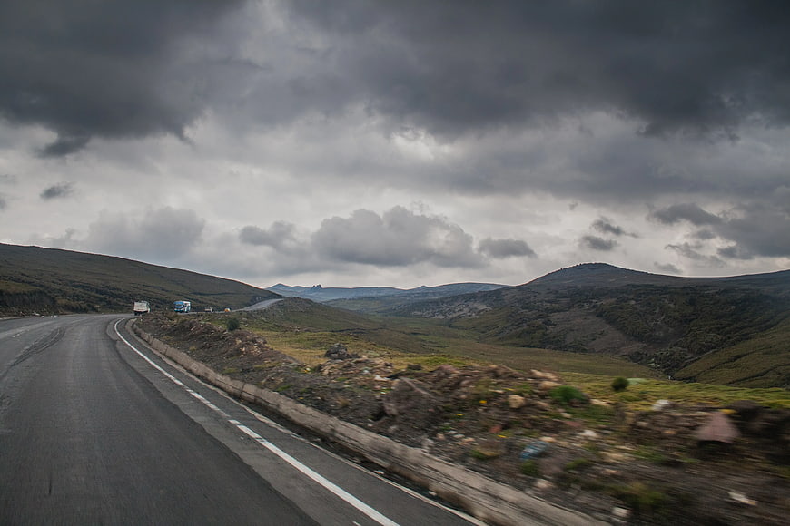 Winding Mountain Road Under Dramatic Cloudy Sky