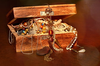 Vintage wooden jewelry box overflowing with necklaces and beads