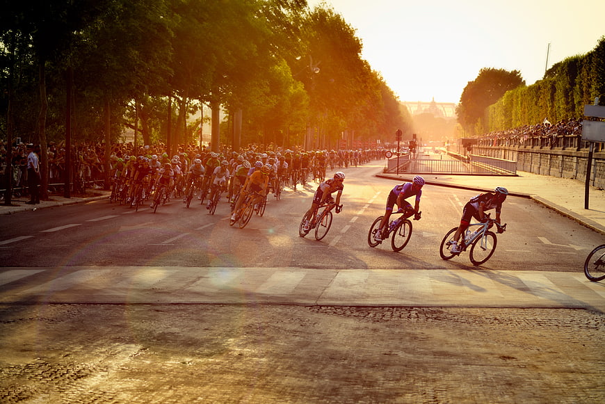 Cyclists racing on Paris street at golden hour