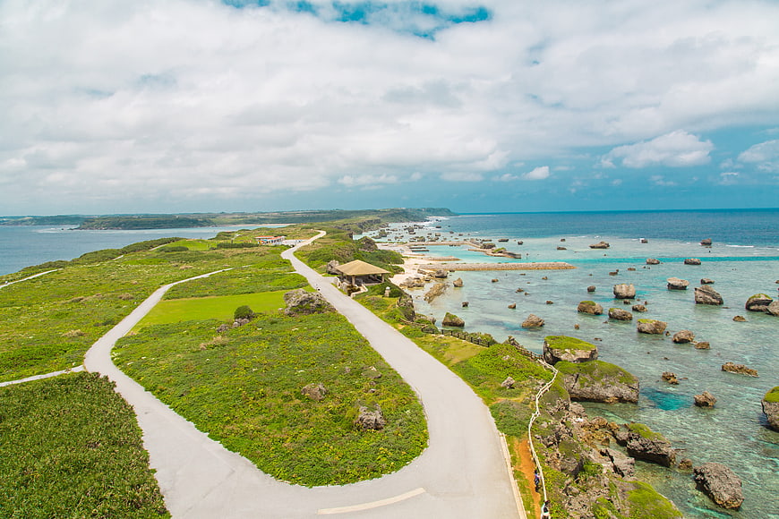 Aerial view of winding coastal road with turquoise ocean and rocks