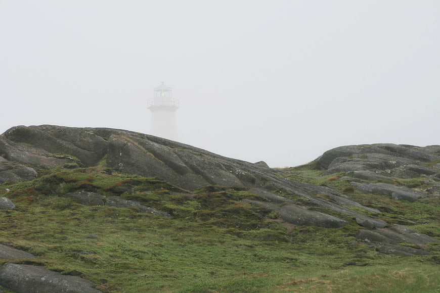 Misty Lighthouse on Rocky Coastal Landscape